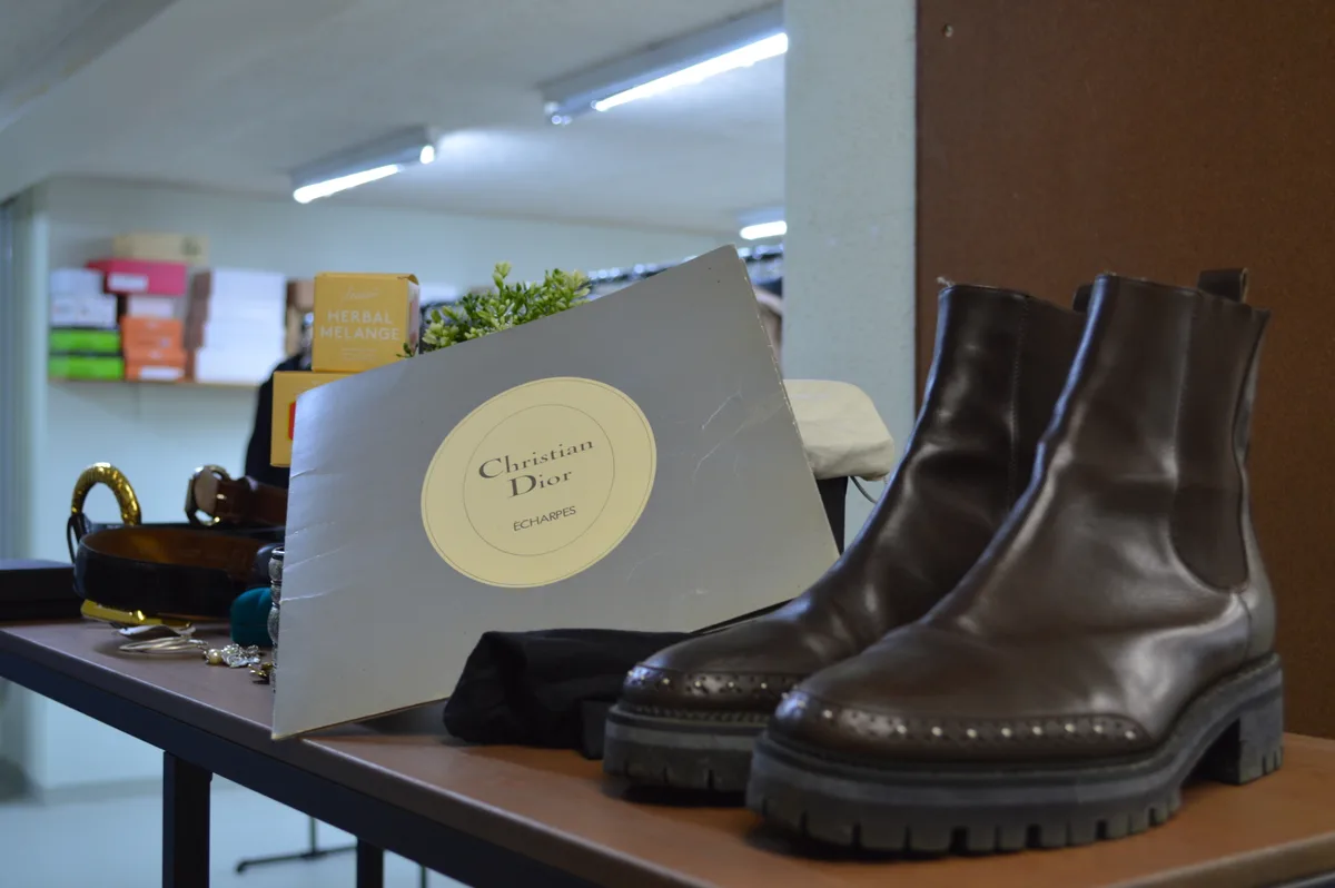 Ein Regal mit Schuhen und einer Christian Dior Tragetasche.